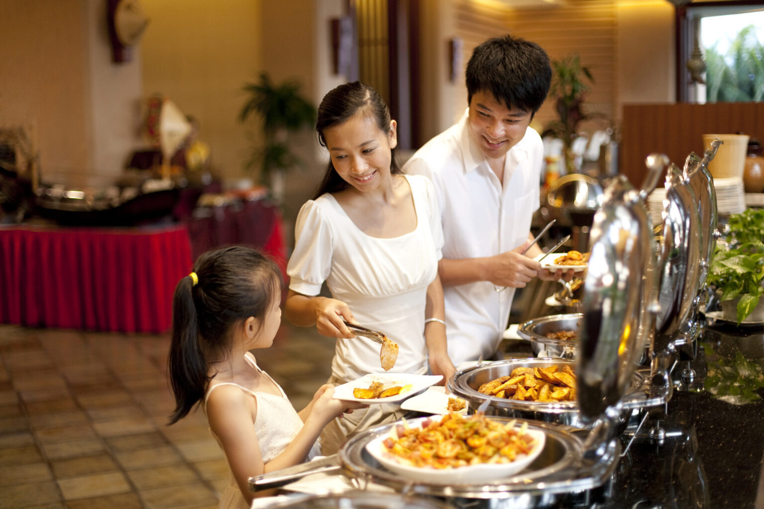 Chinese mother helping her daughter at a buffet